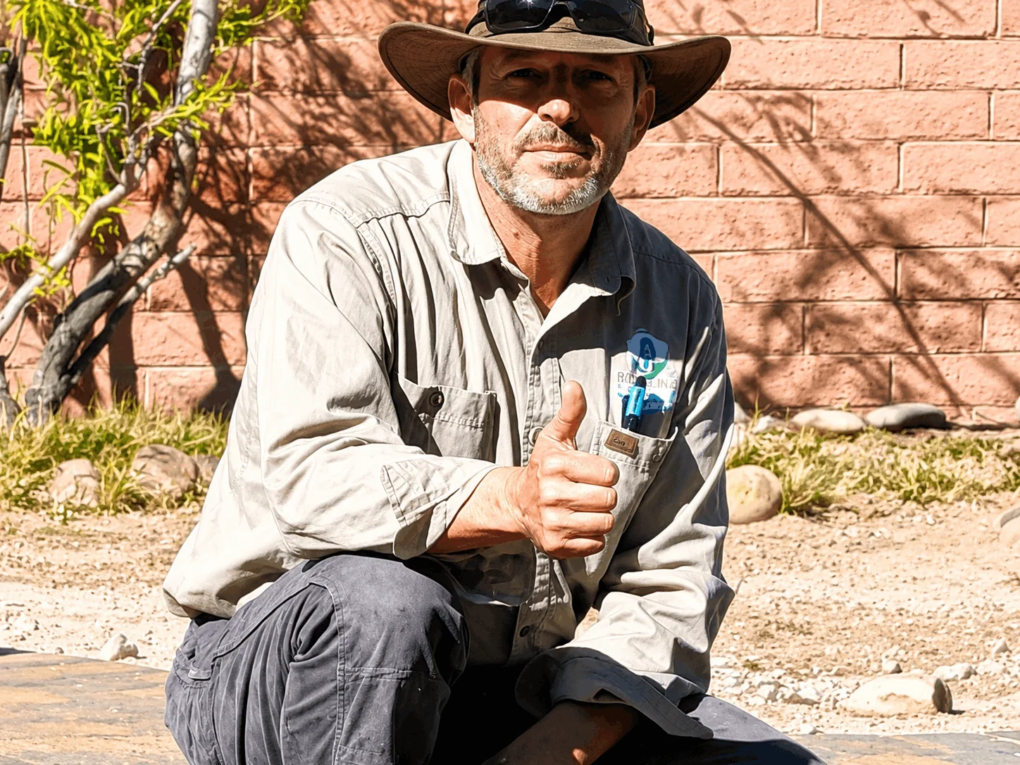 Clint Dunn, founder of Rain Link Irrigation, giving a thumbs-up while working at a Tucson property