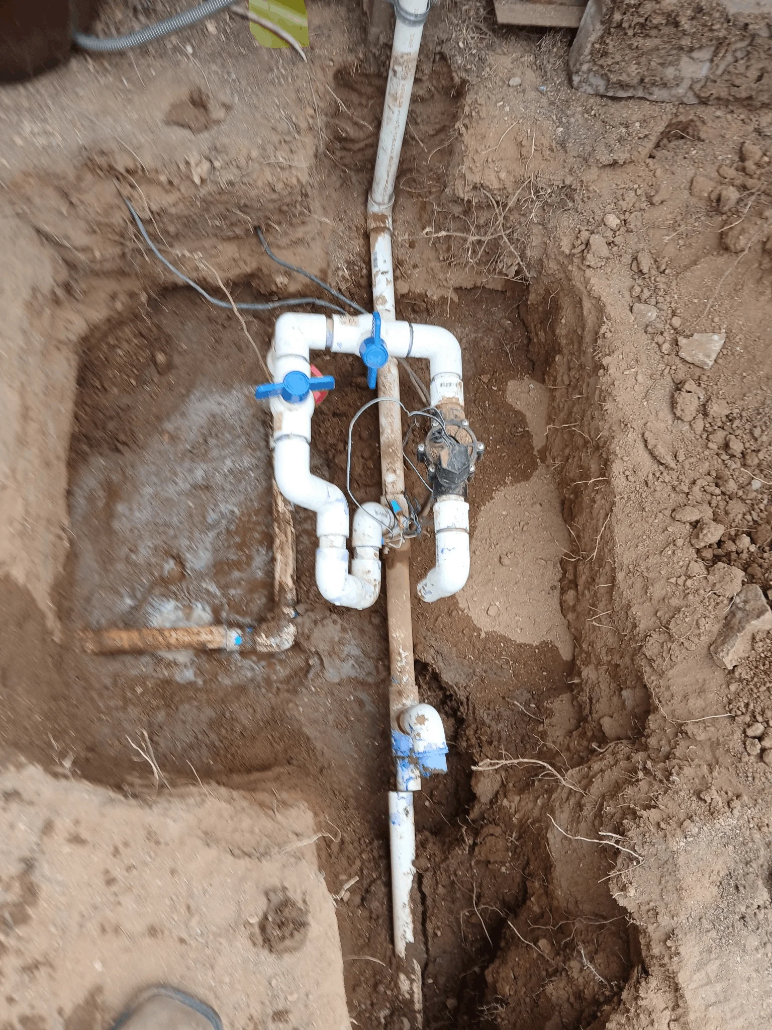 Existing single irrigation valve and PVC piping before irrigation system upgrade in Tucson